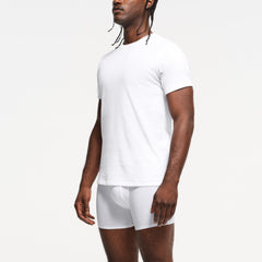 SKIMS BASICS MENS LIGHTWEIGHT T-SHIRT 3-PACK | CHALK ON A MODEL SIDE VIEW