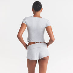 SKIMS SLEEP HENLEY AND FOLDOVER SHORT SET | LIGHT HEATHER GREY ON A MODEL SIDE VIEW @ | FOCUS: 0.0, 1.0, 0.9