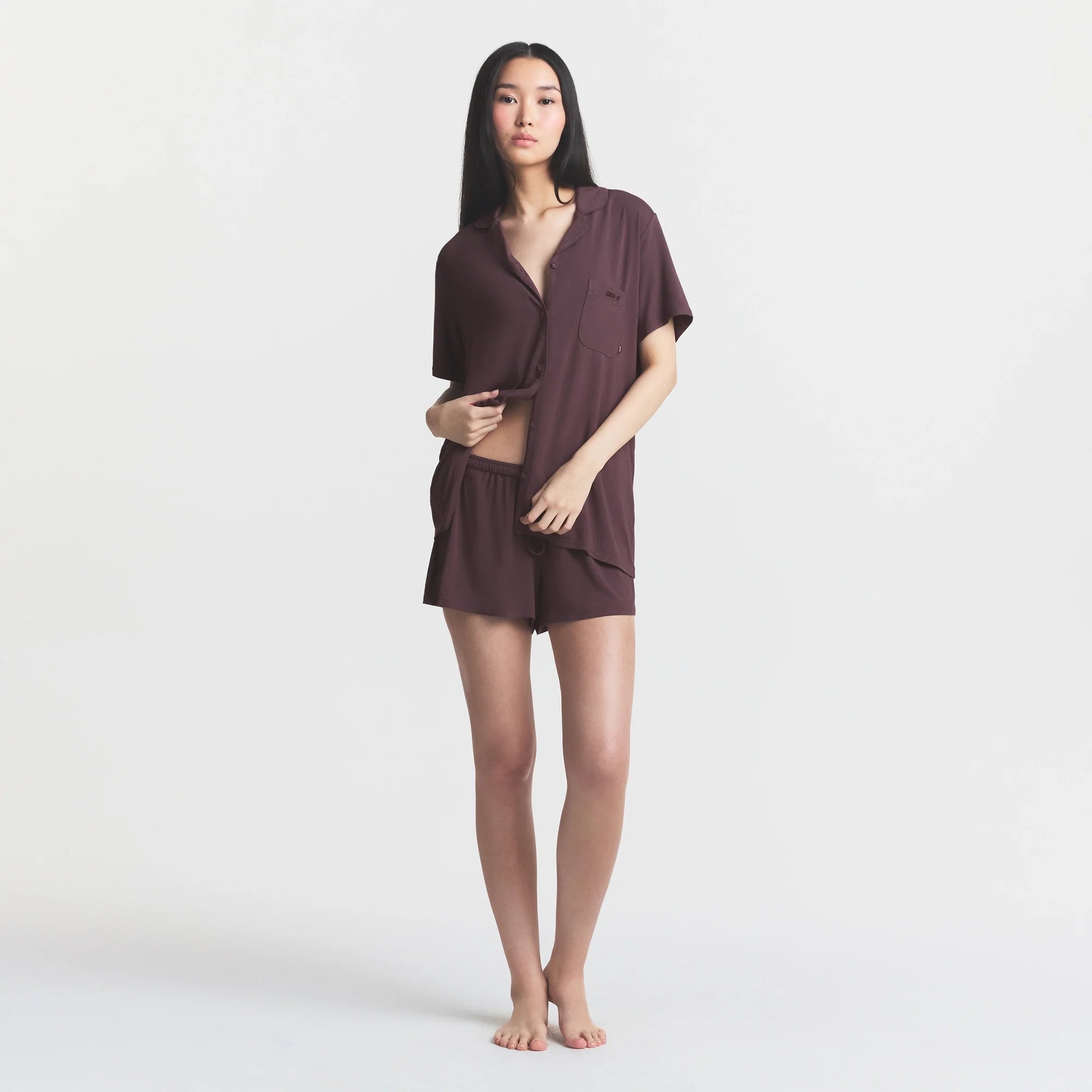 SKIMS SLEEP SHORT SLEEVE BUTTON UP SET | RAISIN ON A MODEL FRONT VIEW @ | FOCUS: 0.0, 1.0, 0.9