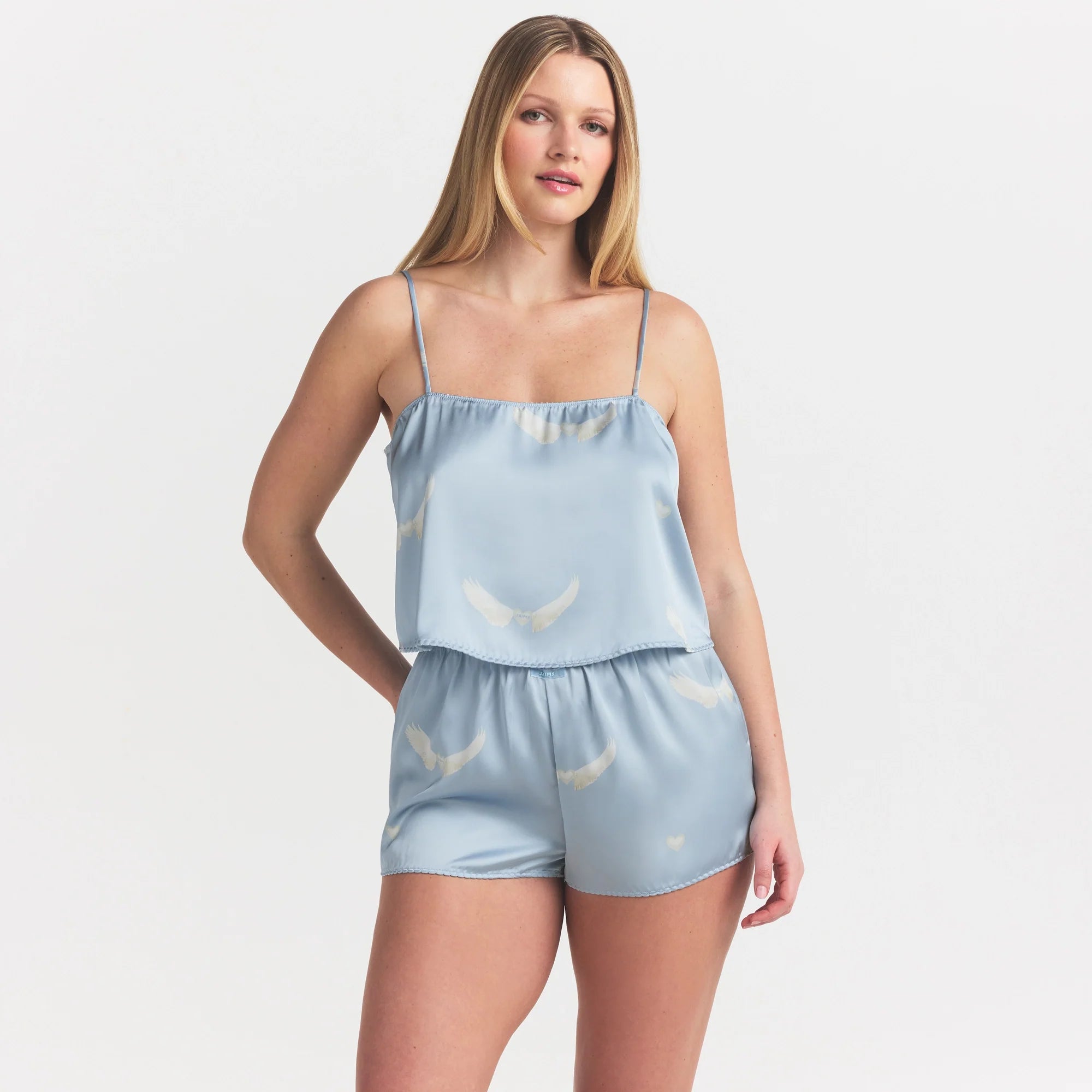 WOVEN SHINE CAMI AND SHORT SLEEP SET | AERO WING HEARTS PRINT ON A MODEL SIDE VIEW @ | FOCUS: 0.0, 1.0, 0.9
