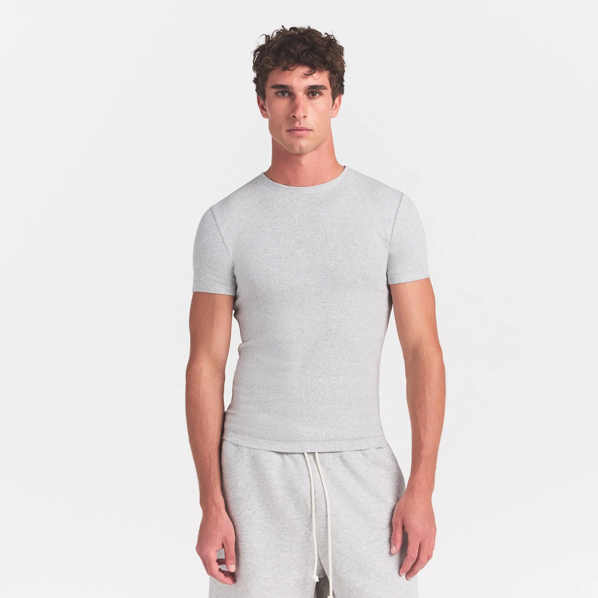 SKIMS COTTON RIB MENS T-SHIRT | LIGHT HEATHER GREY ON A MODEL SIDE VIEW @ | FOCUS: 0.0, 1.0, 0.9