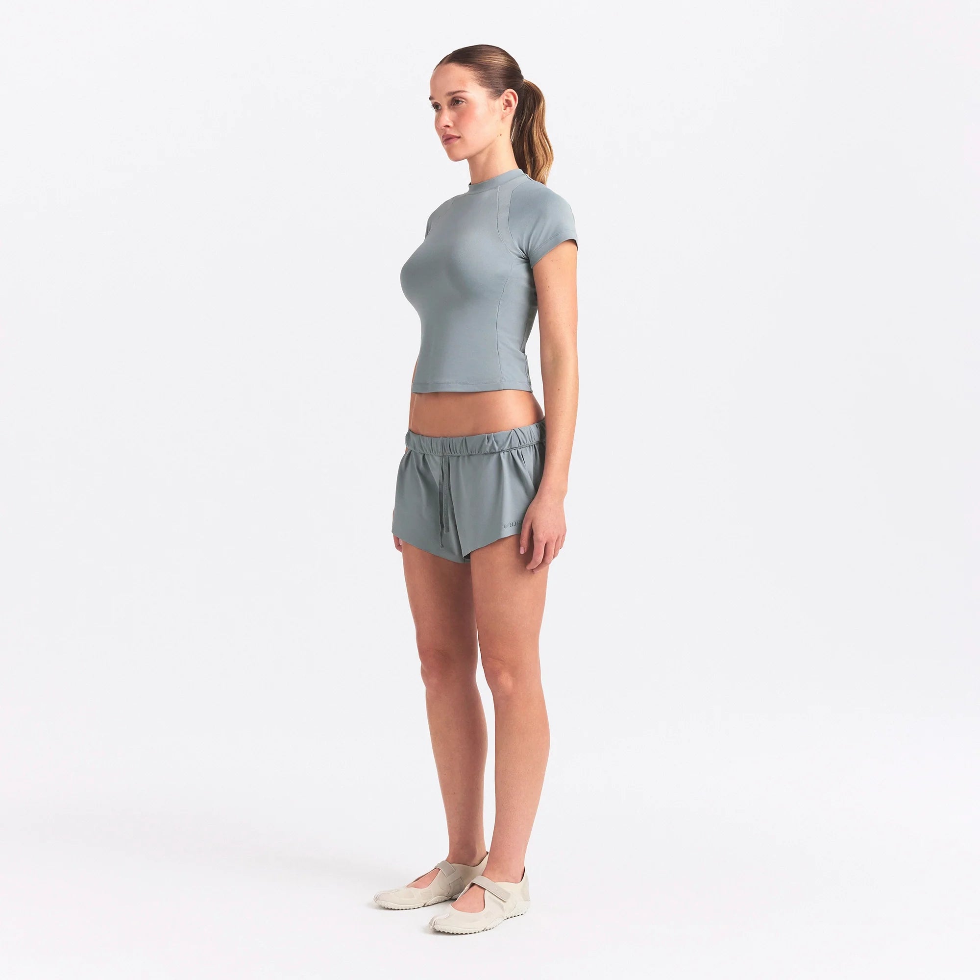 NikeSKIMS AIRY BABY TEE | WASHED PACIFIC ON A MODEL SIDE VIEW @ | FOCUS: 0.0, 1.0, 0.9