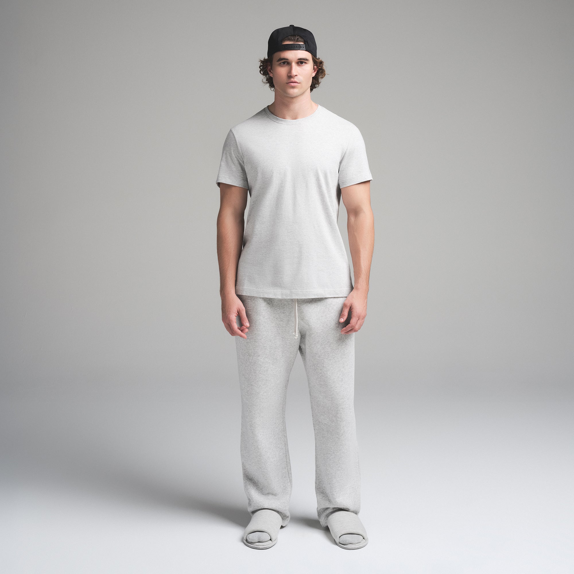 SKIMS COTTON MENS CLASSIC T-SHIRT | LIGHT HEATHER GREY ON A MODEL FRONT VIEW | FOCUS: 0.0, 1.0, 0.9