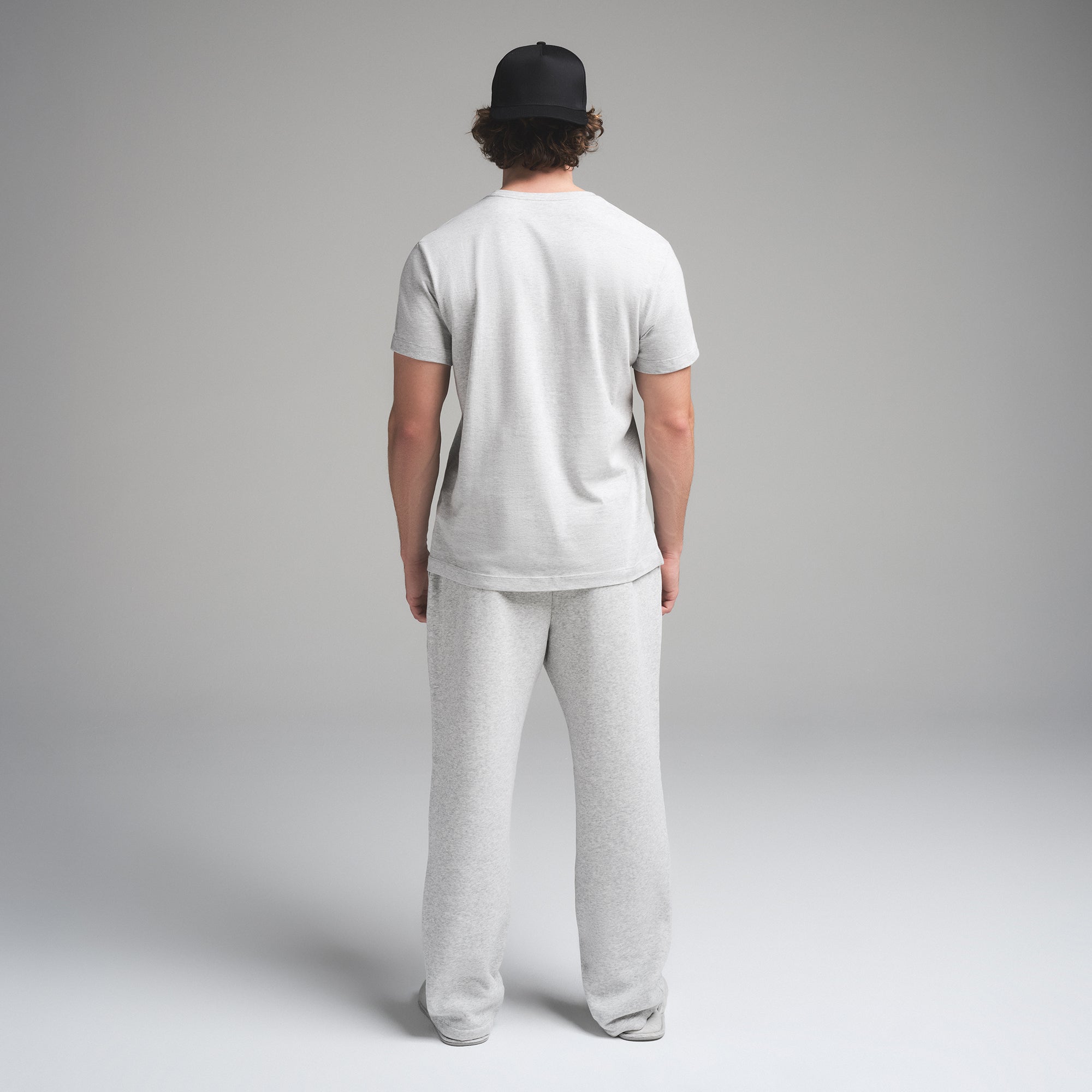 SKIMS COTTON MENS CLASSIC T-SHIRT | LIGHT HEATHER GREY ON A MODEL SIDE VIEW | FOCUS: 0.0, 1.0, 0.9