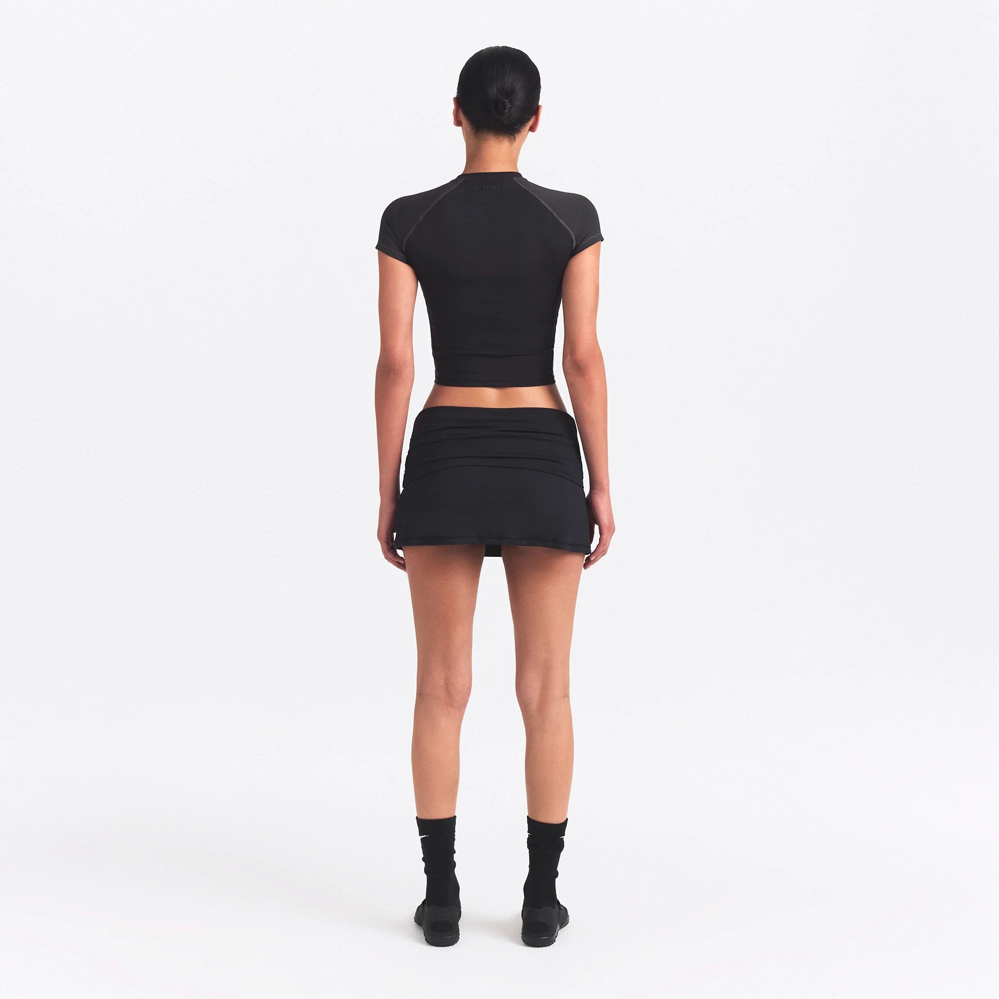 NikeSKIMS MATTE AND SHINE CREWNECK CROP SHORT SLEEVE | OBSIDIAN/IGNEOUS ON A MODEL SIDE VIEW @ | FOCUS: 0.0, 1.0, 0.9