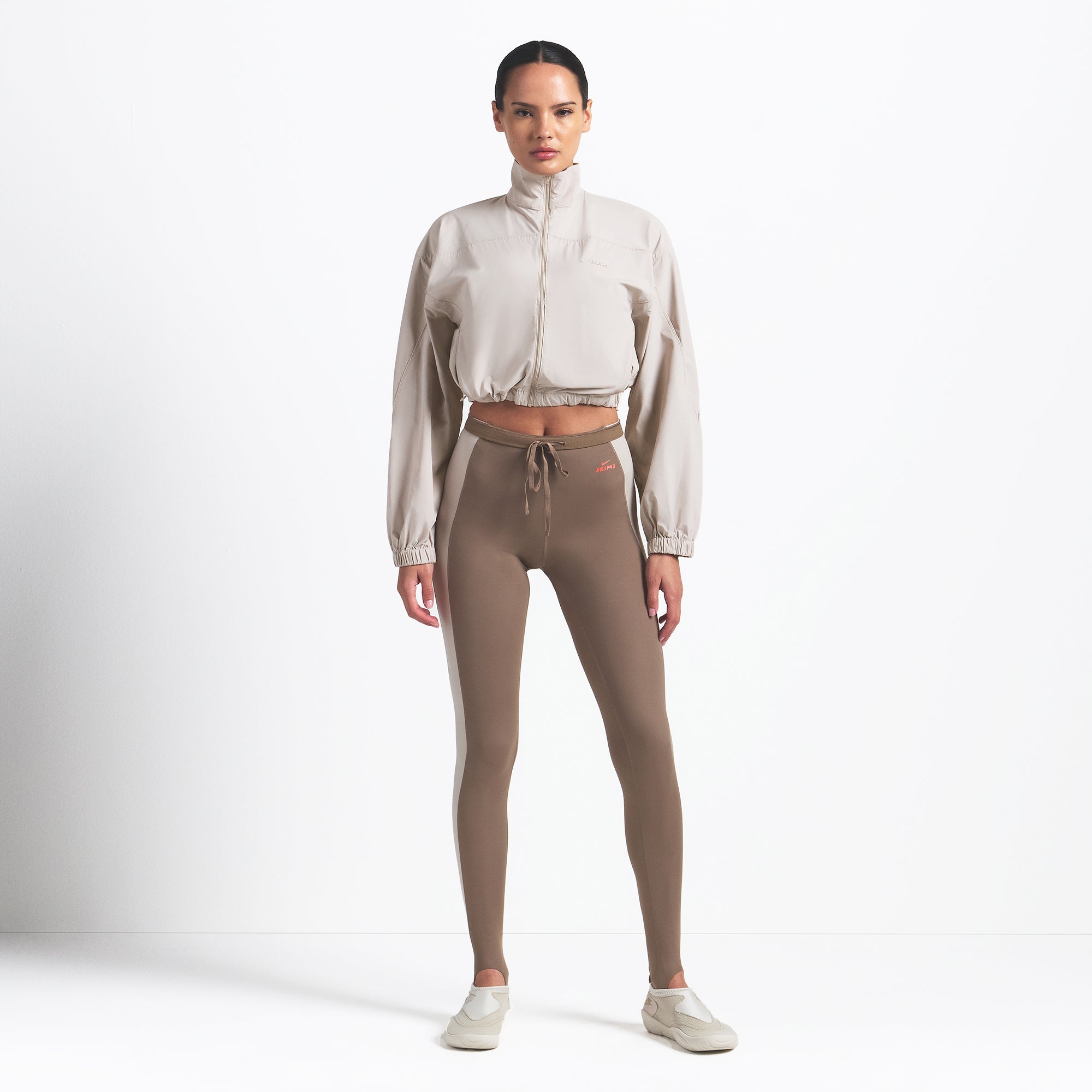 NikeSKIMS WOVEN NYLON CROP JACKET | STONE ON A MODEL FRONT VIEW @ | FOCUS: 0.0, 1.0, 0.9