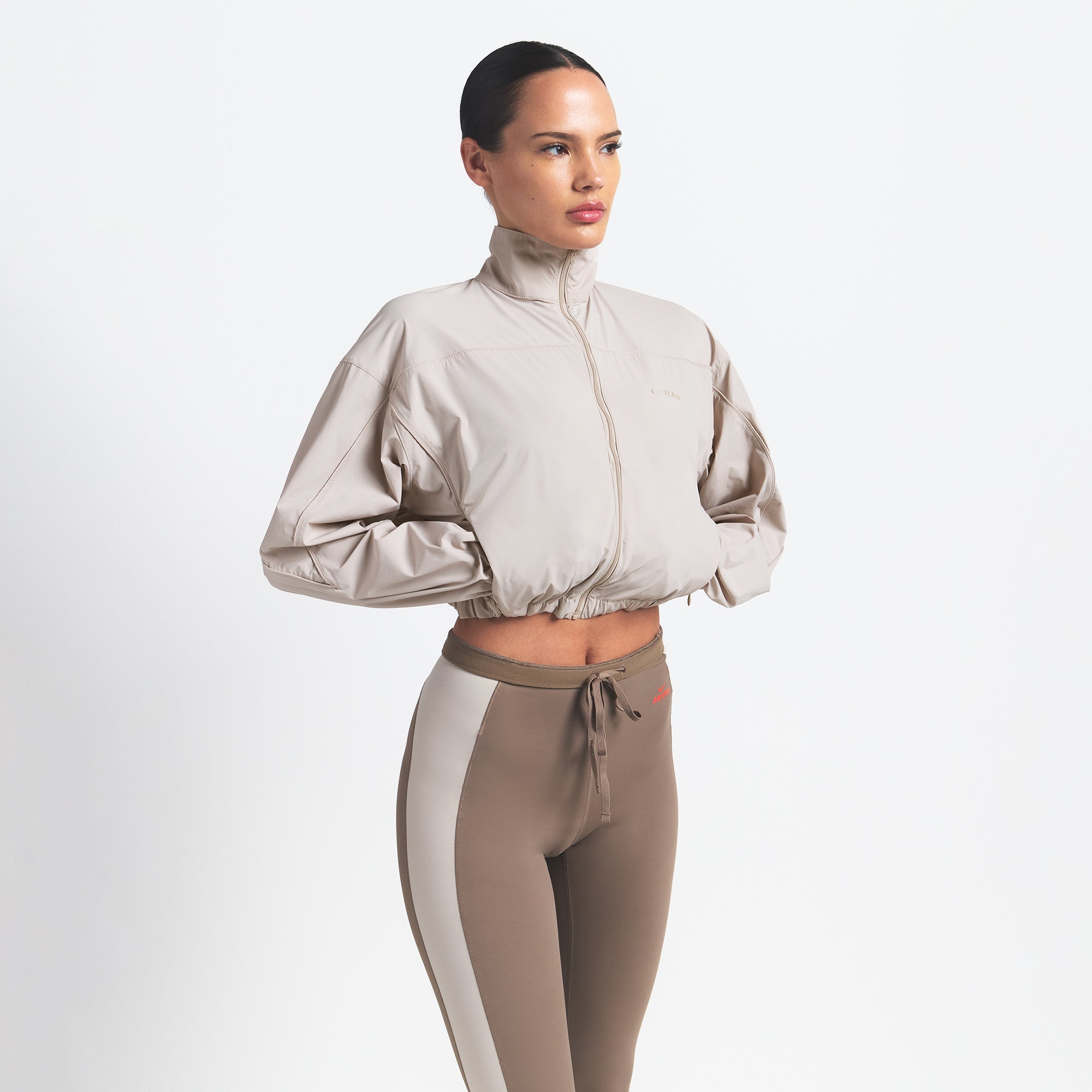 NikeSKIMS WOVEN NYLON CROP JACKET | STONE ON A MODEL SIDE VIEW @ | FOCUS: 0.0, 1.0, 0.9