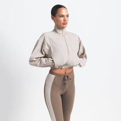 NikeSKIMS WOVEN NYLON CROP JACKET | STONE ON A MODEL SIDE VIEW @ | FOCUS: 0.0, 1.0, 0.9