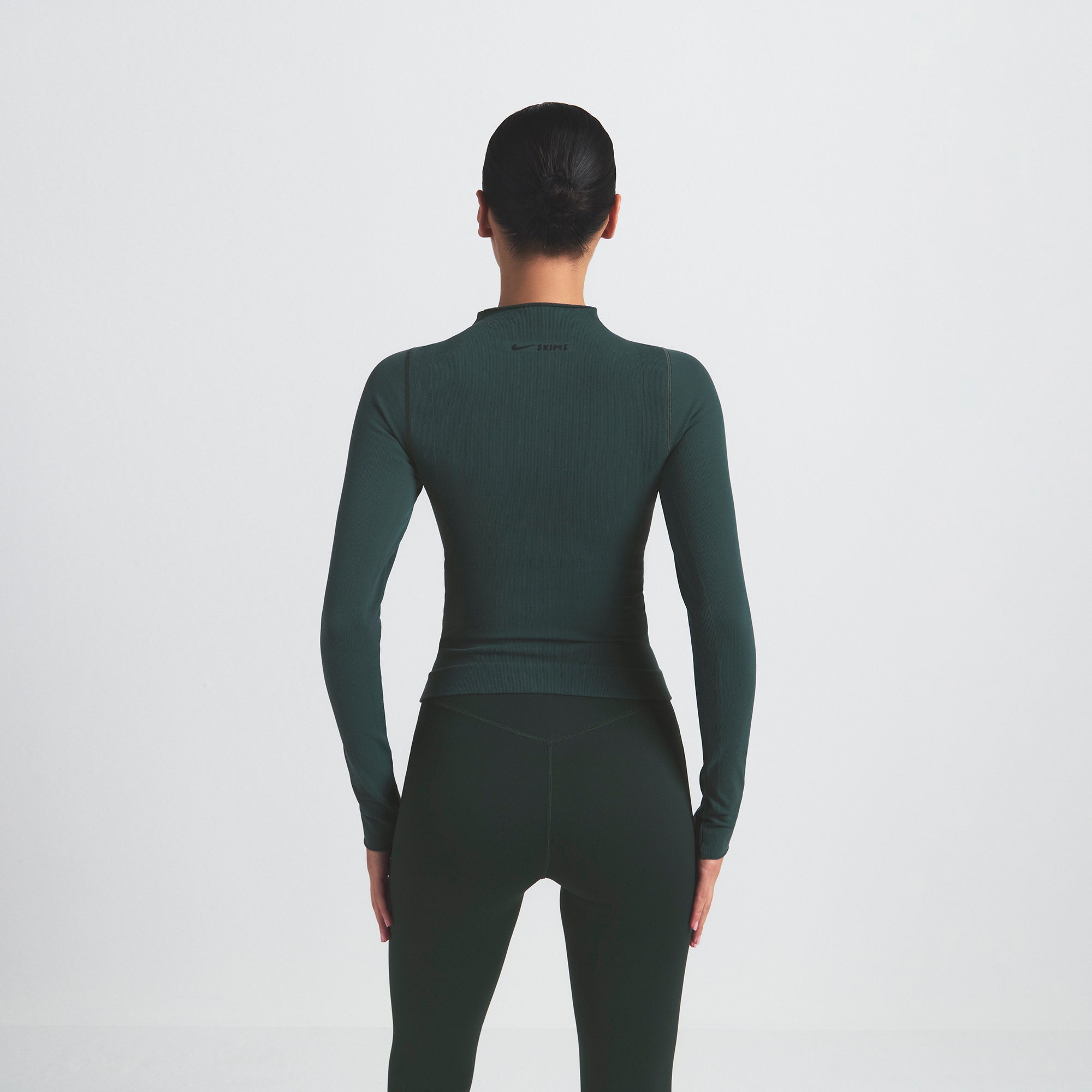NikeSKIMS VINTAGE SEAMLESS FULL ZIP JACKET | DARK TEAL ON A MODEL SIDE VIEW @ | FOCUS: 0.0, 1.0, 0.9